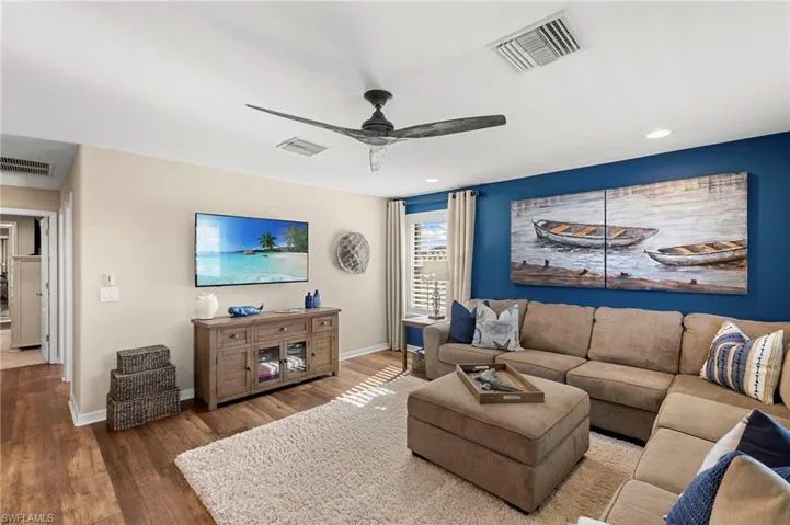 Living area with wood finished floors, ceiling fan, and recessed lighting