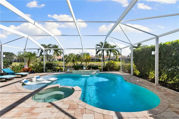 View of pool with a sunroom, a pool with connected hot tub, a lanai, and a patio