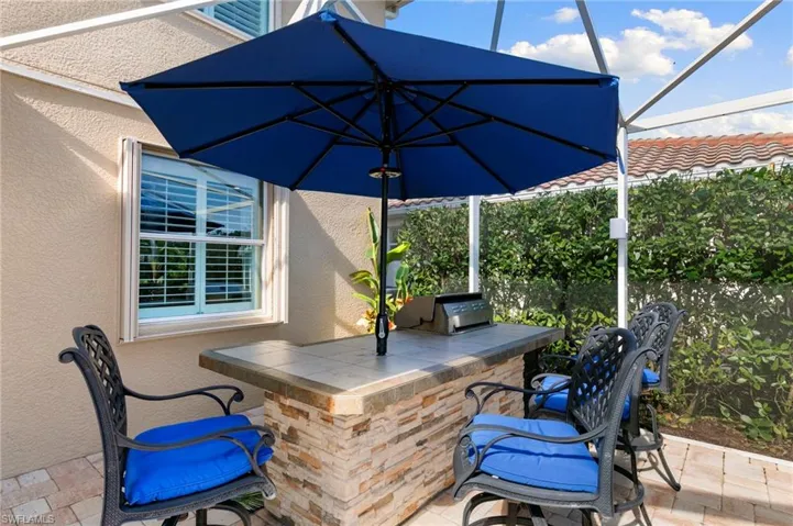 View of patio with glass enclosure, grilling area, and a sunroom