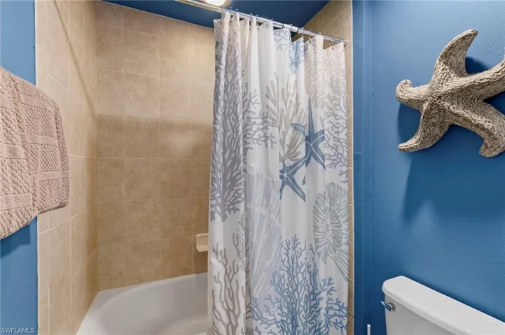 Bathroom featuring shower / bath combo with shower curtain and toilet