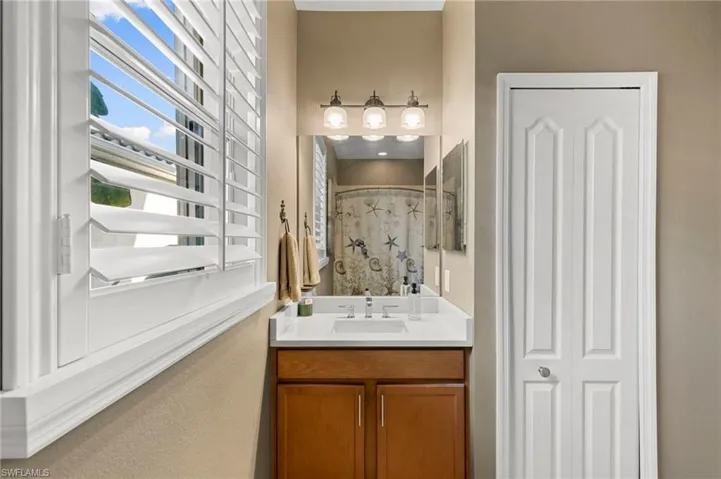 Full bathroom with plenty of natural light, vanity, a shower, and a closet