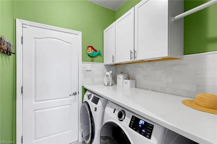 Washroom featuring washing machine and dryer and cabinet space