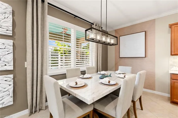 Dining space featuring light tile patterned floors and crown molding