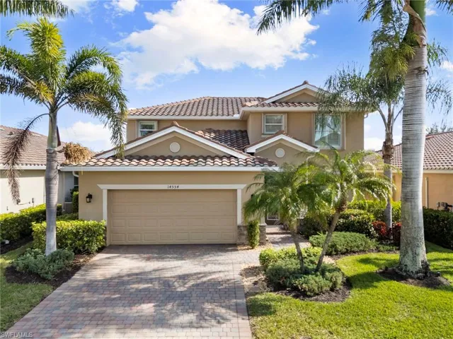 Mediterranean / spanish house featuring a tiled roof, stucco siding, decorative driveway, a garage, and a front lawn