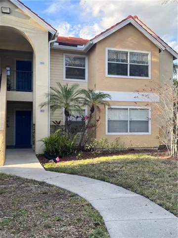 View of front of home featuring stucco siding and a balcony