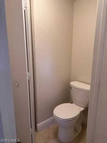 Bathroom featuring light tile patterned flooring and a textured wall