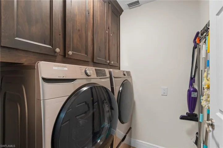 Separate Laundry Area with Front Load Washer & Dryer & Cabinets