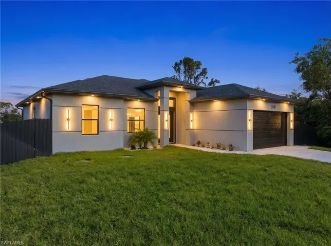 View of front of property featuring stucco siding, a garage, driveway, and a shingled roof
