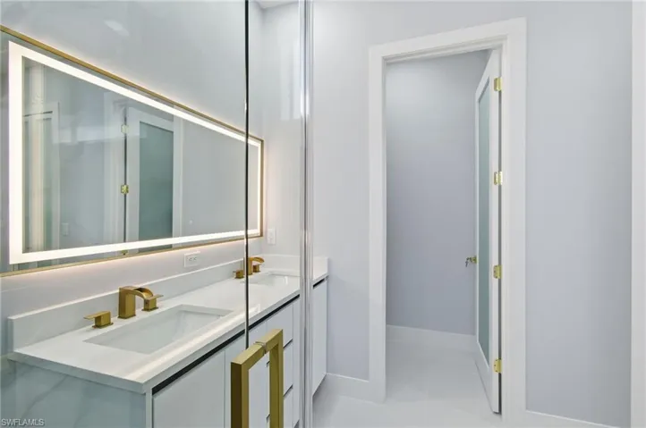 Bathroom featuring double vanity and baseboards