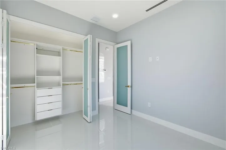 Unfurnished bedroom featuring light tile patterned floors, a closet, and recessed lighting