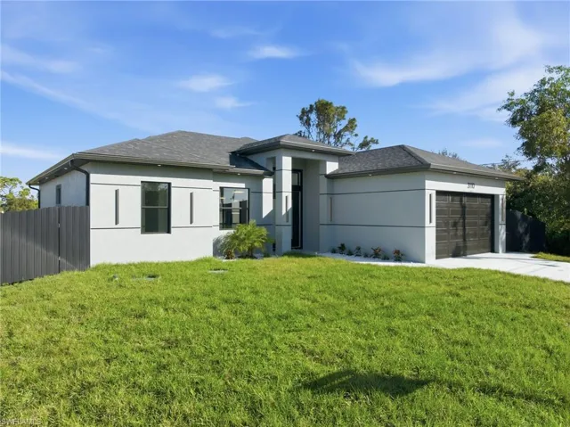 Prairie-style home with a garage, concrete driveway, and stucco siding