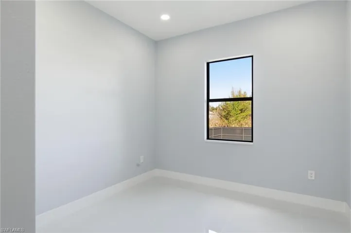 Tiled empty room with baseboards and recessed lighting