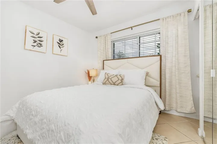 Bedroom featuring ceiling fan, tile patterned floors, and a closet