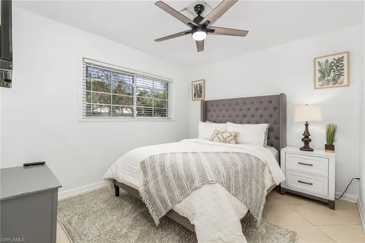 Bedroom with light tile patterned floors and a ceiling fan