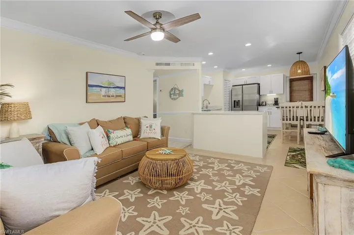 Living room featuring ornamental molding, ceiling fan, light tile patterned floors, and recessed lighting