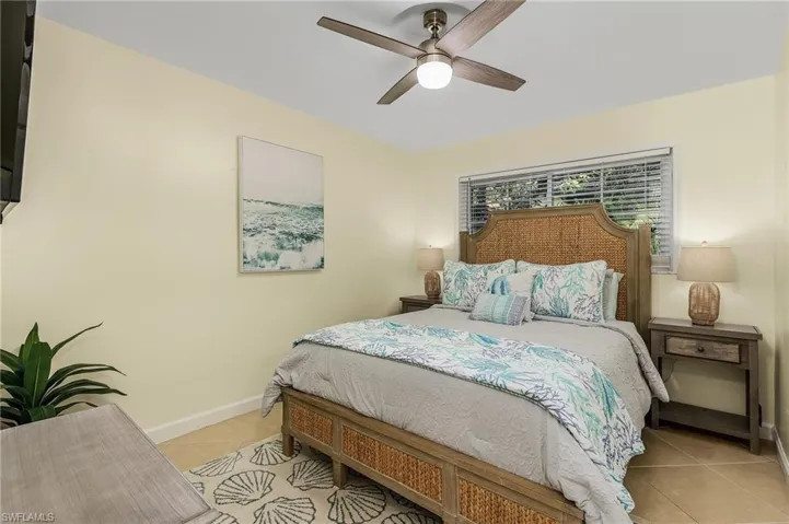 Bedroom with a ceiling fan and light tile patterned flooring