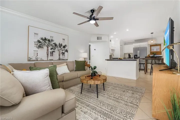 Living area featuring crown molding, ceiling fan, light tile patterned floors, and recessed lighting