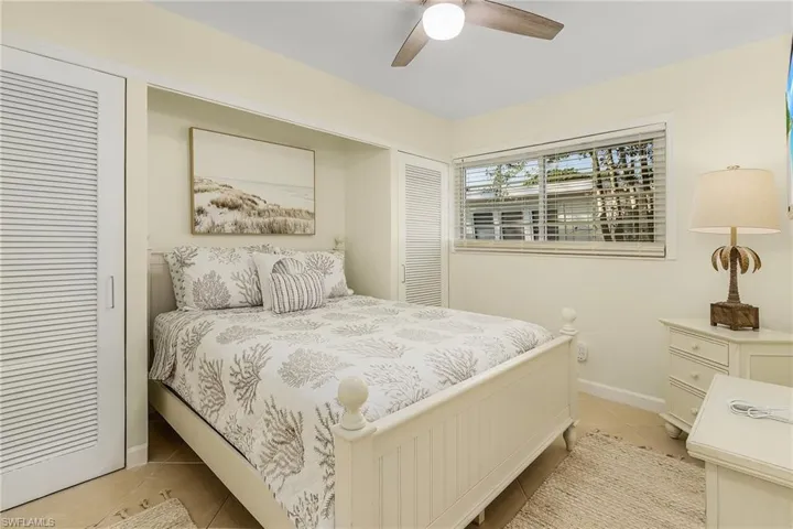 Bedroom with light tile patterned flooring and ceiling fan