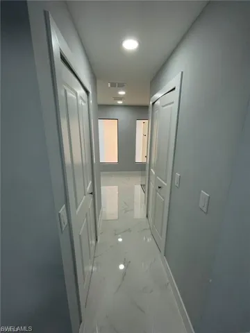 Corridor with light marble finish flooring and baseboards
