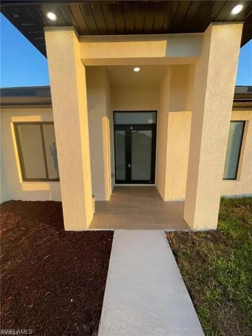 Doorway to property featuring stucco siding