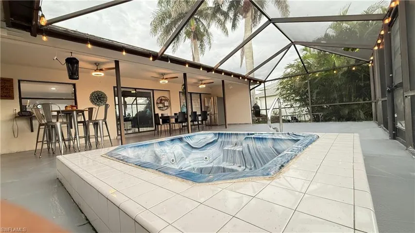 Swimming pool with a patio, a ceiling fan, and glass enclosure
