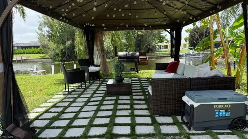 View of patio / terrace with a water view, outdoor lounge area, and a gazebo