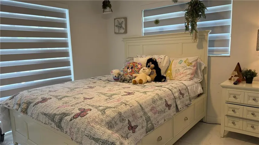 Bedroom featuring light marble finish floors