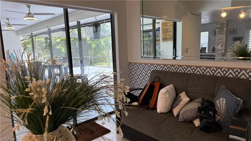 Living area featuring ceiling fan and tile patterned floors
