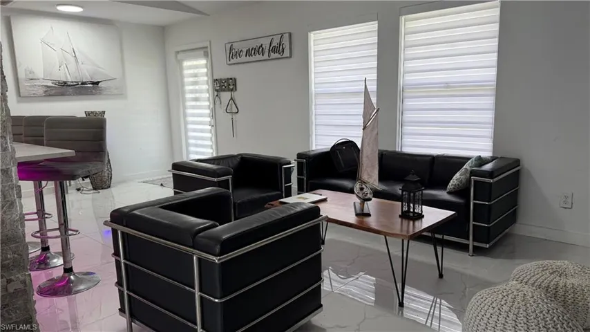 Living room featuring marble finish flooring and baseboards