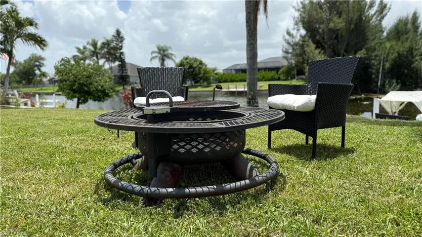 View of green lawn featuring an outdoor fire pit