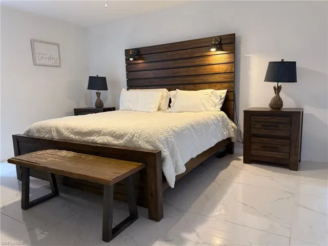 Bedroom featuring light marble finish floors