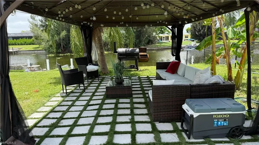 View of patio / terrace featuring an outdoor living space, a water view, a gazebo, and area for grilling