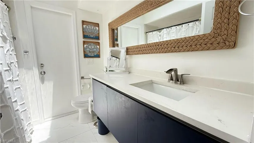 Bathroom with marble look tile flooring and vanity