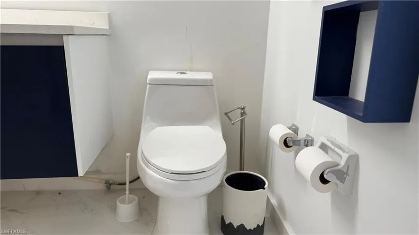 Bathroom featuring toilet and marble look tiles
