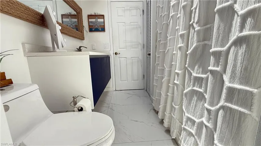 Bathroom featuring marble finish flooring and vanity