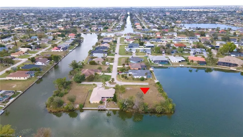 Aerial view of property and surrounding area with a nearby body of water and nearby suburban area