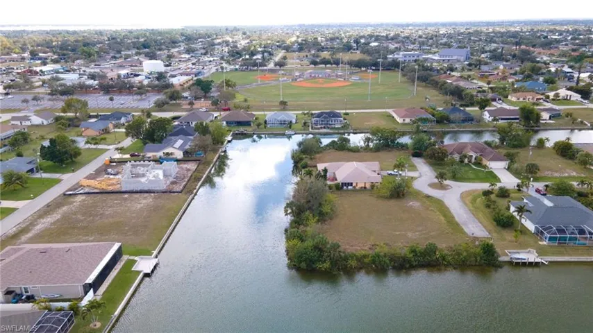 Aerial view of property's location with a large body of water and nearby suburban area