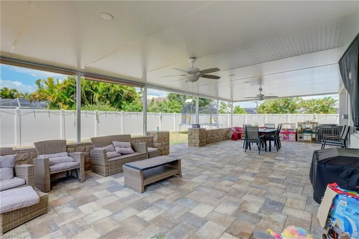Fenced backyard featuring a ceiling fan, an outdoor living space, a patio, and outdoor dining space