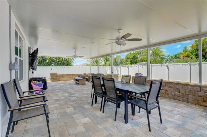 Fenced backyard featuring a ceiling fan, a patio, outdoor dining space, and an outdoor hangout area