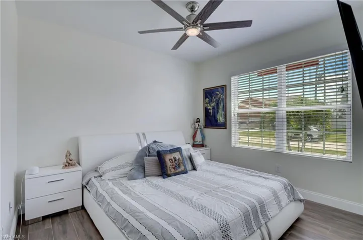 Bedroom with dark wood-type flooring and a ceiling fan