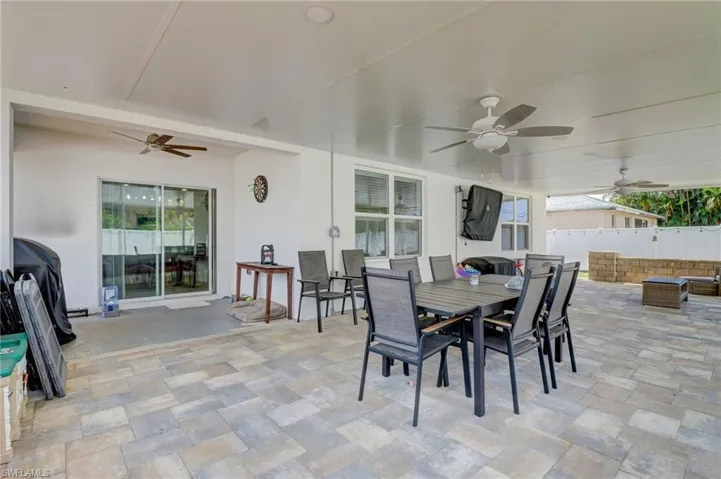 View of patio with ceiling fan and outdoor dining area