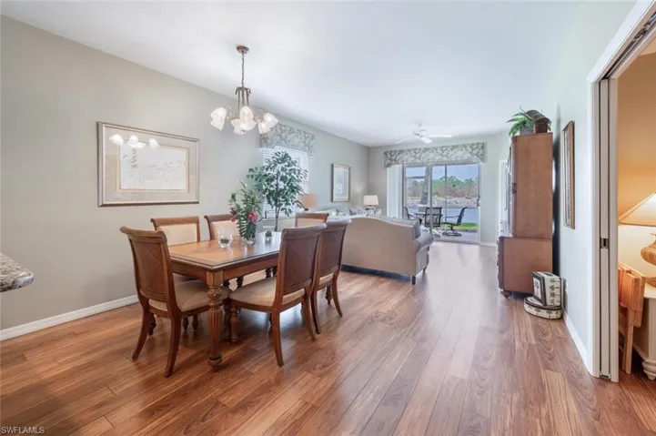 Dining room with hardwood / wood-style flooring and ceiling fan with notable chandelier