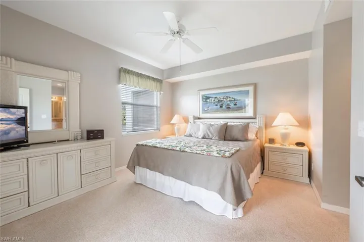 Carpeted bedroom featuring ceiling fan