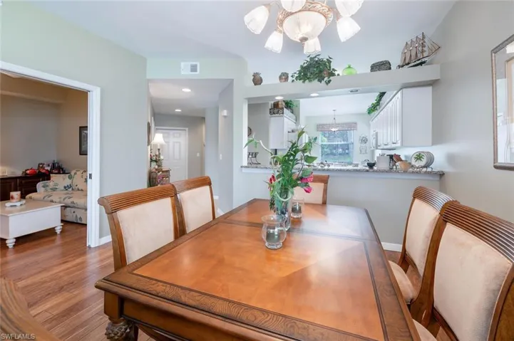 Dining area with a notable chandelier and wood-type flooring