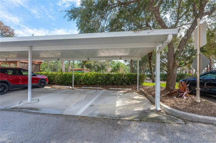 View of parking / parking lot with a carport