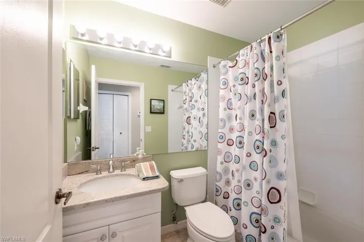 Full bathroom with vanity, toilet, and shower / bathtub combination with curtain