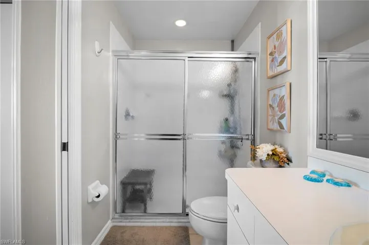 Bathroom featuring a stall shower, vanity, and recessed lighting