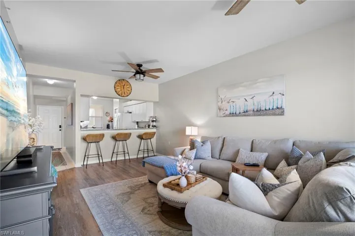 Living room featuring a ceiling fan and dark wood finished floors