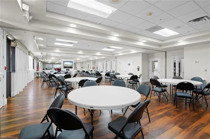 Dining area with dark wood-style floors, a tray ceiling, and a paneled ceiling
