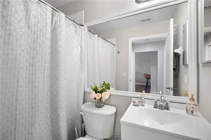 Bathroom with a shower with shower curtain and vanity